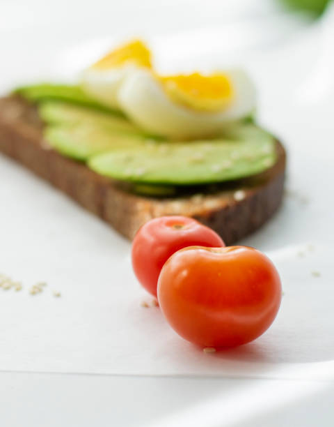 Egg and avocado sandwich.Toast with avocado and egg on rustic wooden background.