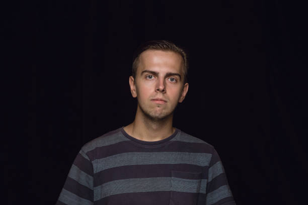 istock Close up portrait of young man isolated on black studio background 1158149341