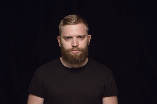 istock Close up portrait of young man isolated on black studio background 1158149368