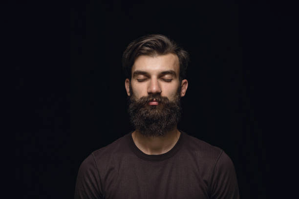 istock Close up portrait of young man isolated on black studio background 1158149403