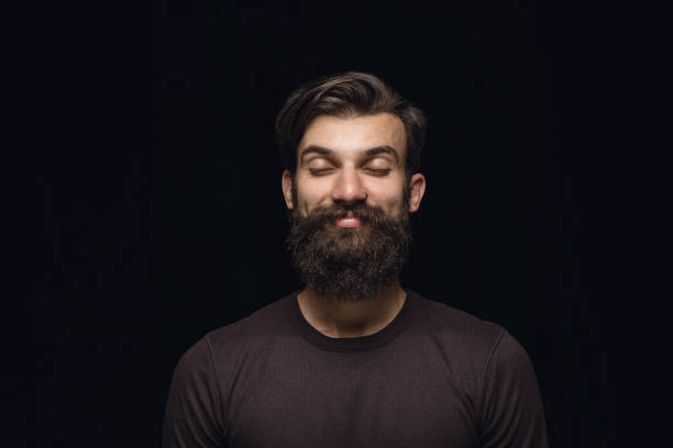 istock Close up portrait of young man isolated on black studio background 1158149421