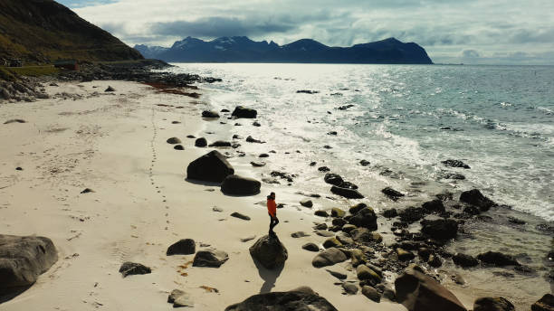 istock Aerial drone view: man running in Lofoten Islands 1158156389
