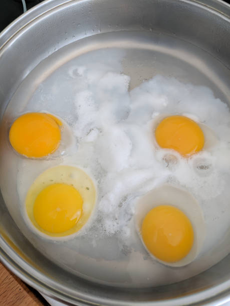 braconnage d'œufs frais dans une casserole d'eau. - poached photos et images de collection