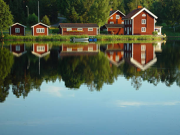 istock red painted Swedish lakeside houses reflection 115815668