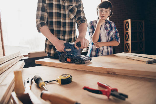 istock Cropped view of two nice creative person master handyman artisan dad fixing creating construction showing teaching son interesting occupation at modern studio loft industrial brick interior 1158156767
