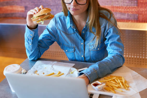 istock Crop freelancer eating burger and using laptop 1158156810