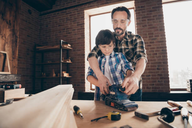 istock Portrait of two nice person concentrated focused creative hard-working woodworkers master handymen dad teaching son old-fashioned profession at modern loft industrial brick interior 1158157660