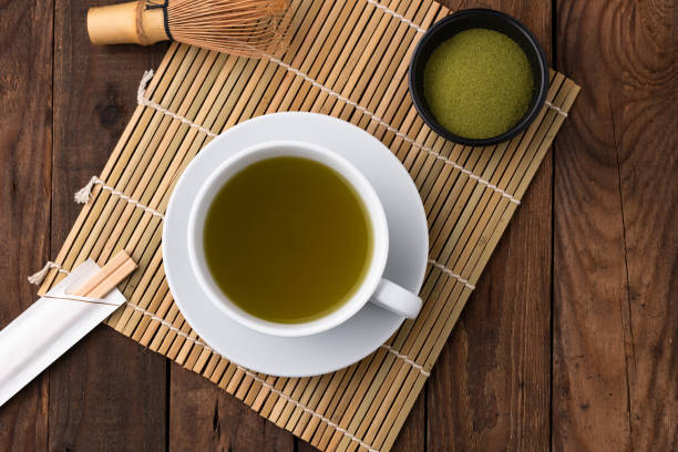 istock hot green tea in cup on wood 1158157707
