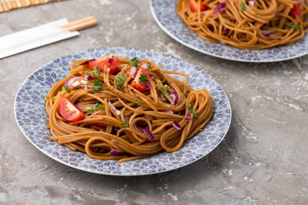 istock Udon stir fry noodles with vegetables in plate with chopsticks 1158157708