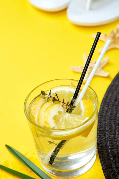 Holidays and drink concept. Cold cocktail, lemonade with lemon mint  in a glass on a yellow table. Summer background. Detox water.