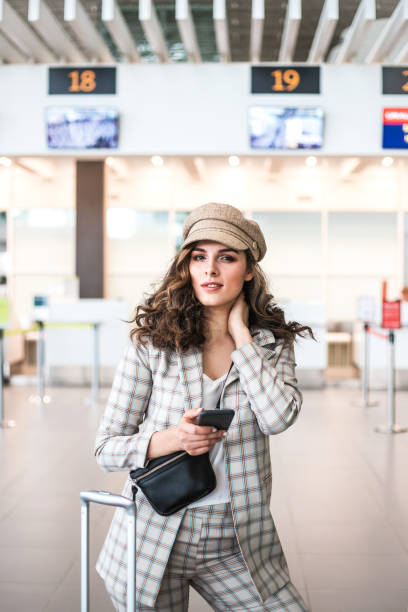 young beautiful woman reading phone messages in airport waiting room. - airport waiting room waiting airport lounge imagens e fotografias de stock