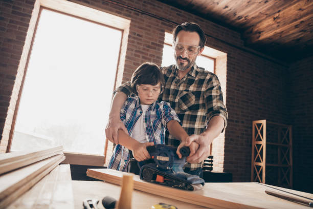 istock Low angle view of two nice smart clever creative cheerful person master builder dad fixing creating repairing building cabinetry restoration at modern studio loft industrial brick interior indoors 1158160494