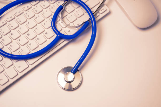 istock Blue stethoscope on computer keyboard on white table background. Online medical information treatment technology concept, close up, macro, copy space 1158160526
