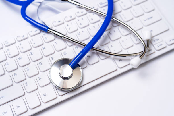 istock Blue stethoscope on computer keyboard on white table background. Online medical information treatment technology concept, close up, macro, copy space 1158160544