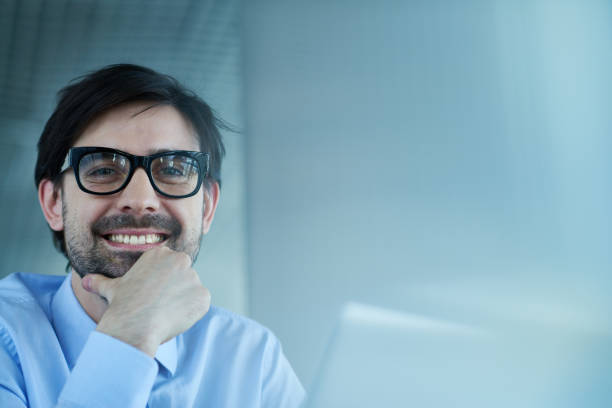 istock Cheerful businessman with laptop looking at camera 1158160644