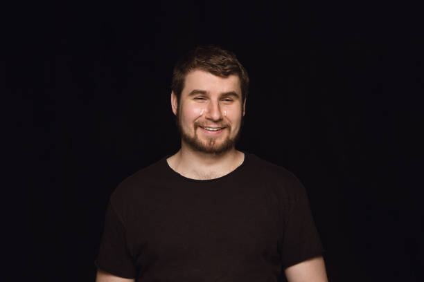 istock Close up portrait of young man isolated on black studio background 1158160661