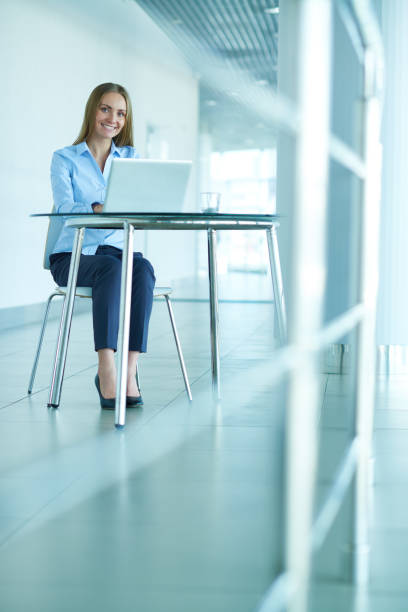 istock Smiling female manager with laptop looking at camera 1158161030