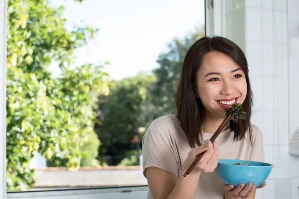 Beautiful Chinese woman smiling and enjoying healthy food