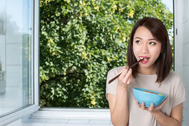 Beautiful and healthy Chinese woman enjoying healthy food
