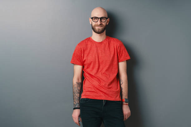 istock Young smiling man with beard and glasses on gray studio background 1158169397