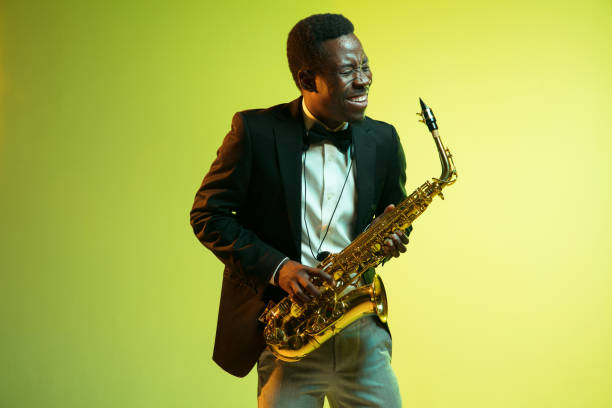 молодой афро-американский джазовый музыкант играет на саксофоне - cool jazz стоковые фото и изображения
