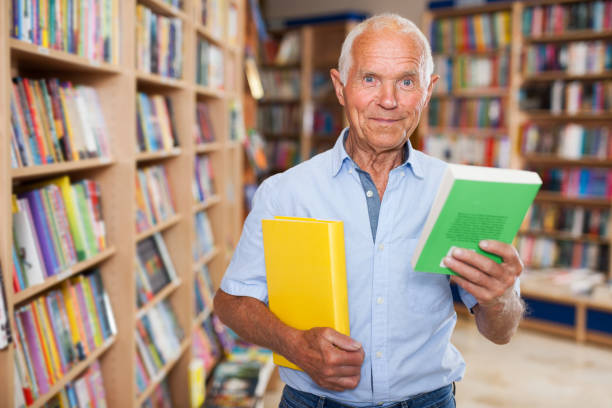 istock Older man choosing books in bookstore 1158172417