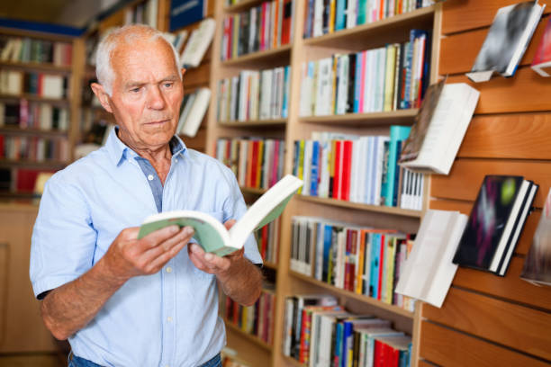 istock Focused elderly man looking for information in books in bookstore 1158172473