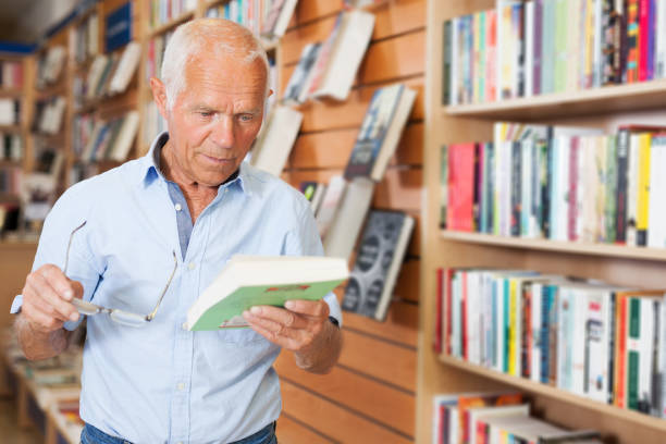 istock man absorbedly searching for interesting books 1158172484