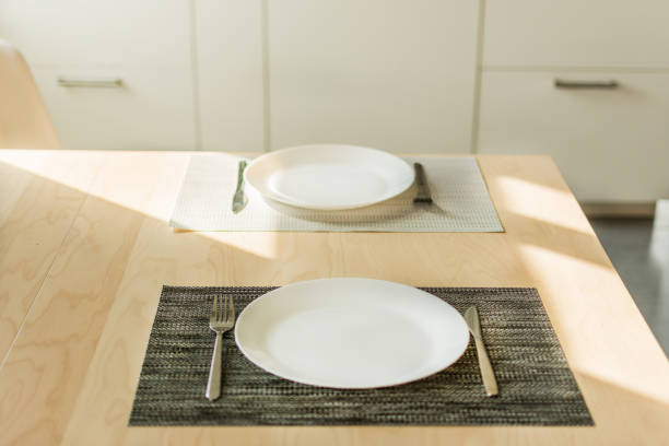 istock Empty plate with fork and knife on wooden table in the kitchen interior. 1158175218