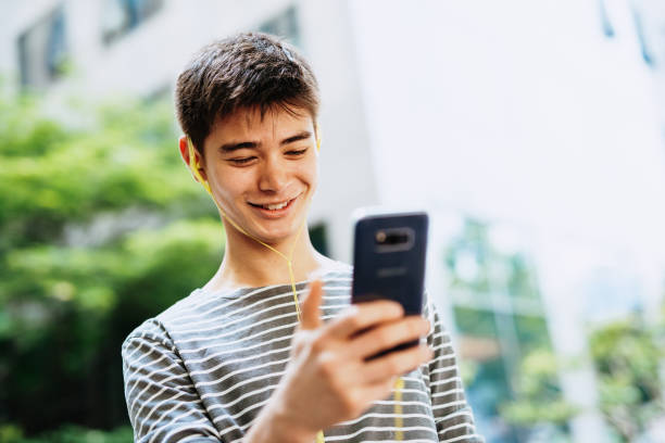 istock Handsome Korean man using mobile phone outdoors 1158178770