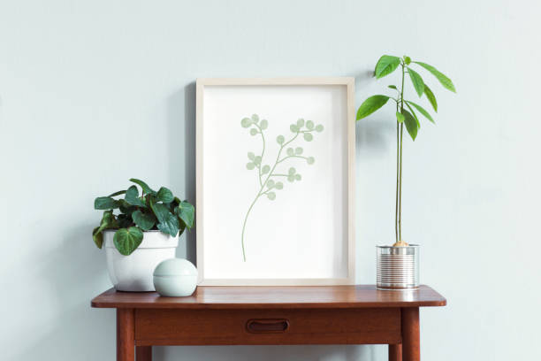 istock Stylish scandinavian interior with design retro table, white mock up photo frame and beautiful plants in design pots and accessories. Modern home decor. Gray background wall. Minimalistic concept. 1158178847