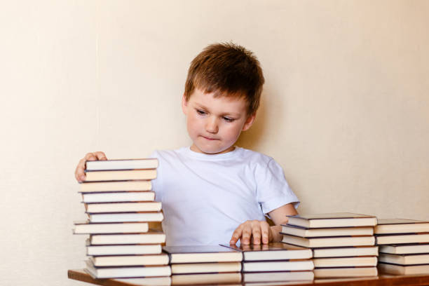 istock cute six-year-old boy and many books. learn to read. 1158179281