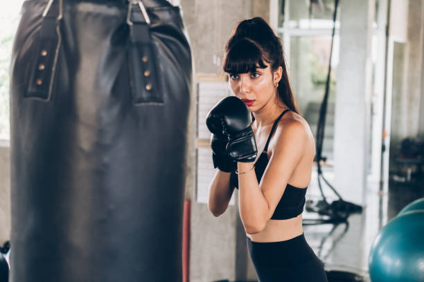 istock Female boxer punching bag 1158181044