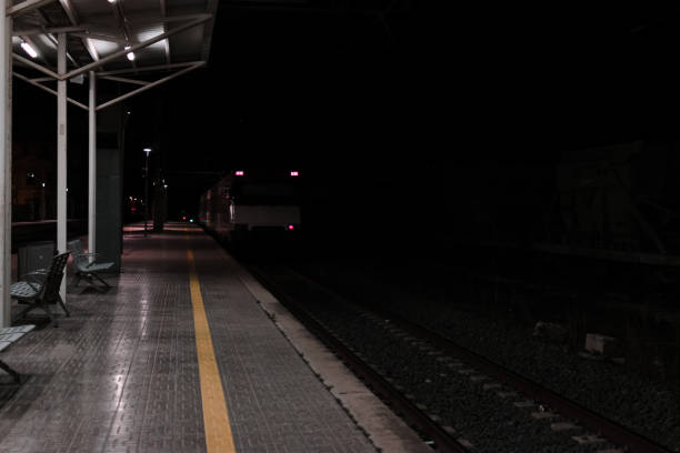 istock Empty rail road station at night. The train is going on the tracks. 1158181054