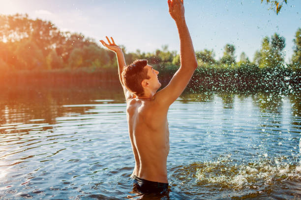 istock Young man in water and making splash. Summer vacation 1158182129
