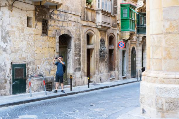 A mid adult traveler creating memories by using his camera phone.