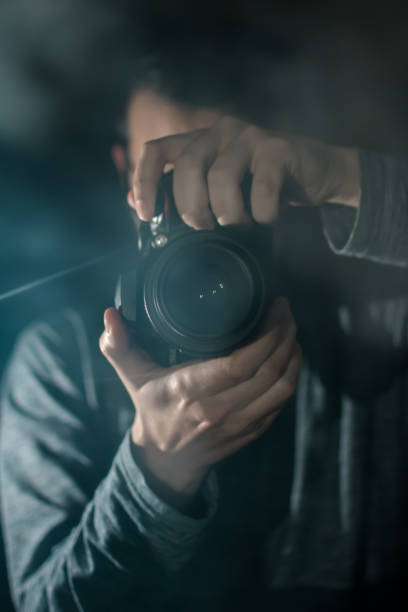 istock Professional photographer with a camera. Black background. 1158182430