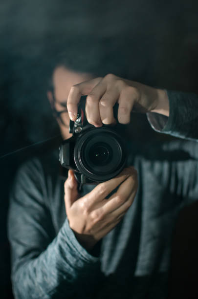 istock Professional photographer with a camera. Black background. 1158182438
