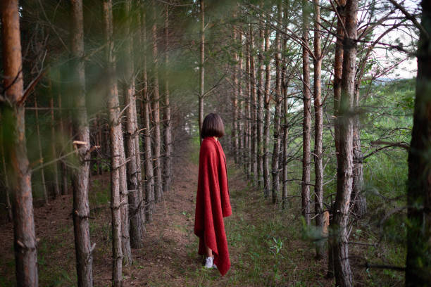 istock Brunette in red plaid standing among trees 1158183518