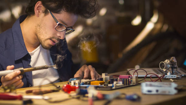 istock Student is studying electronics and soldering a circuit board in a garage. 1158183699