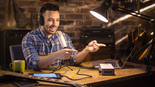 el joven hace una grabación de audio de podcast en casa en un garaje. - dj de radio fotografías e imágenes de stock