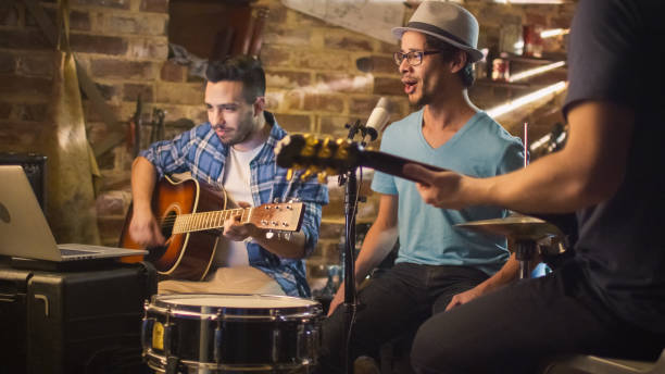 istock Band sing and play guitars while recording a song and practicing in a home studio in a garage. 1158183763