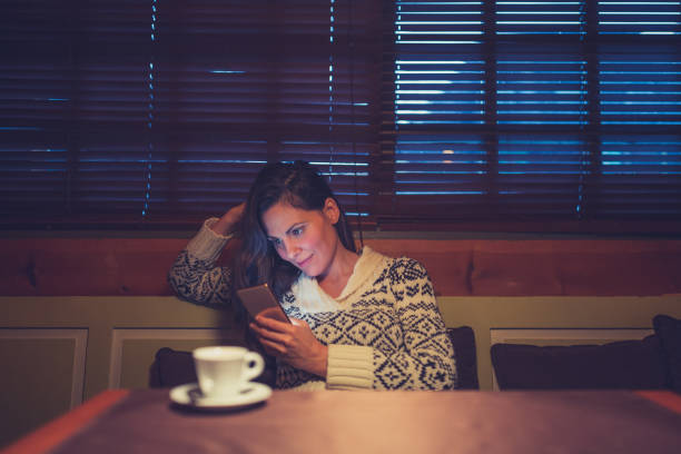 istock Young woman enjoy in cafe, drinking coffee and using mobile phone. Its winter time. 1158184966
