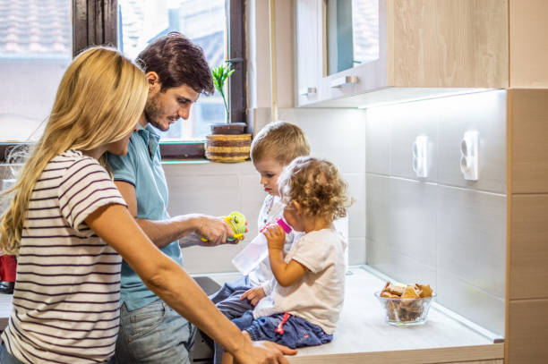 istock Young smiling parents enjoying with their kids in the kitchen 1158189975