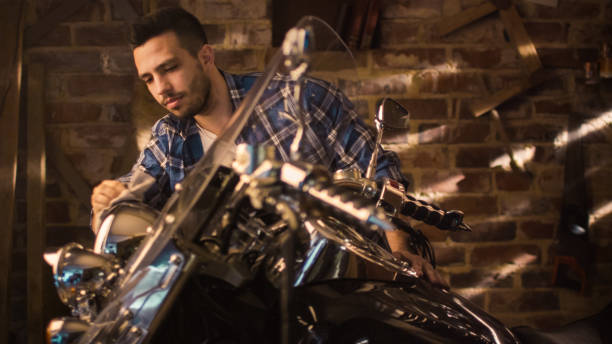 istock Man is cleaning and polishing chrome objects on his motorcycle in a garage. 1158190024