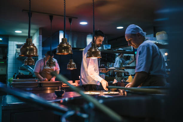 Teamwork in the kitchen. Teamwork in the kitchen. Chef, waiter and all the other stuff, perfectly work together busy restaurant tables stock pictures, royalty-free photos & images