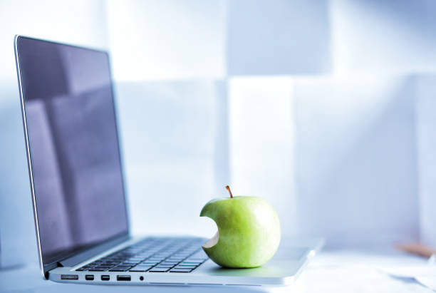 istock laptop and a bitten green apple on it 1158194337