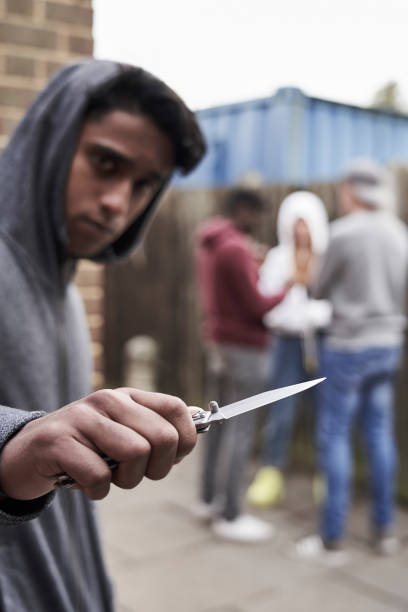 подросток в городской банды указывая ножом к камере - threats men african descent caucasian стоковые фото и изображения