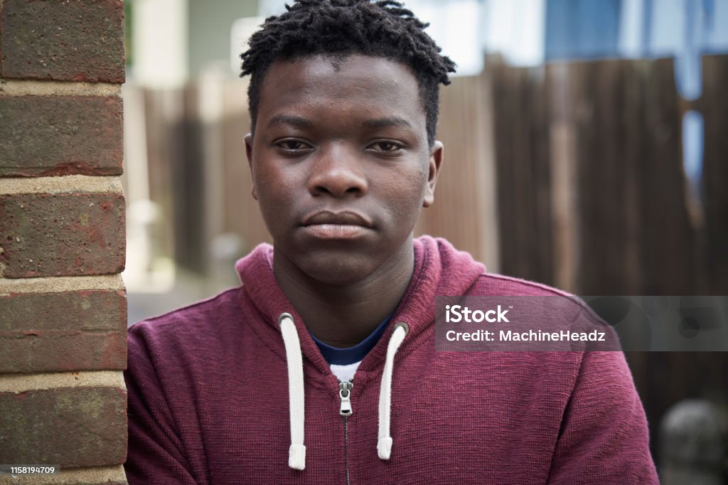 Portrait Of Serious Teenage Boy Leaning Against Wall In Urban Setting Portrait Of Teenage Boy Leaning Against Wall In Urban Setting Teenager Stock Photo