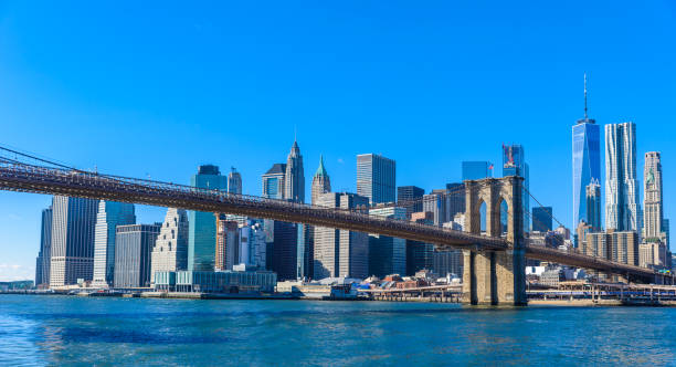 famoso skyline del centro de la ciudad de nueva york, brooklin bridge y manhattan con rascacielos iluminados sobre el panorama de east river. nueva york, estados unidos - manhattan dusk new york state sunrise fotografías e imágenes de stock